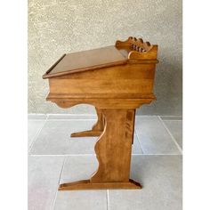 a small wooden piano sitting on top of a tile floor