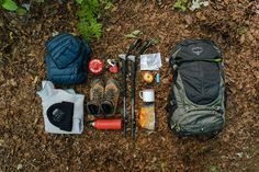 the contents of a backpack laid out on the ground next to hiking gear and equipment