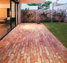 an outdoor patio with brick pavers and sliding glass doors leading to the back yard