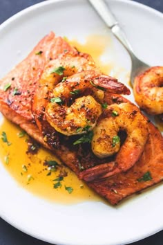 a white plate topped with grilled salmon and shrimp