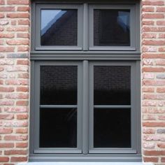 an open window on the side of a brick building with two panes and no windows