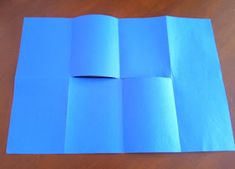 folded blue paper sitting on top of a wooden table