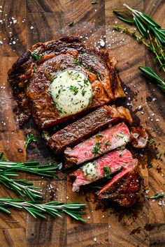 sliced steak on a cutting board with herbs and butter in the center, ready to be served