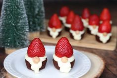 some strawberries are sitting on a plate with white frosting and red berries in the background