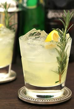 two glasses filled with lemonade and rosemary garnish