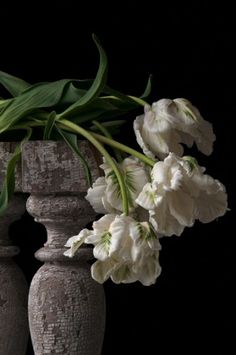 some white flowers are in a gray vase