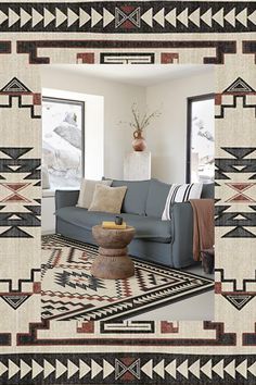 a living room with a blue couch and rugs on the floor in front of a window