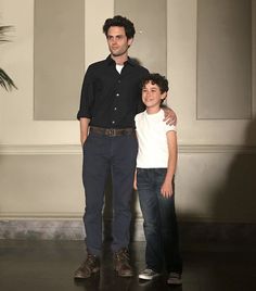 a man standing next to a little boy