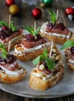 small appetizers are arranged on a plate with toothpicks