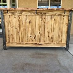 an outdoor bar made out of wood with metal bars on the top and bottom, in front of a house