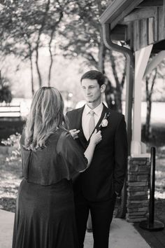 a man in a tuxedo adjusting his tie to a woman's dress