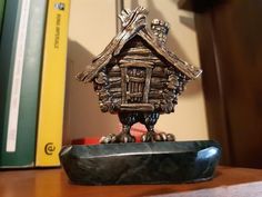 a figurine is sitting on a desk next to some books and a book case