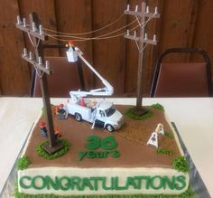 there is a cake that looks like it has construction equipment on top and the words congratulationss are spelled in green