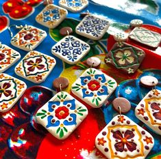 some very pretty decorated cookies on a colorful table cloth with other items in the background