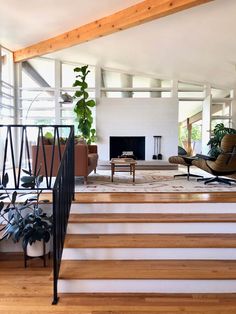 a living room filled with furniture and a fire place in the middle of a wooden floor