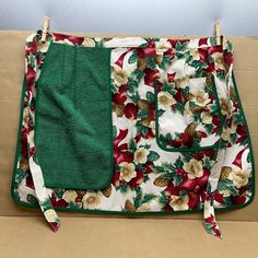 an oven mitt sitting on top of a wooden table next to a green towel