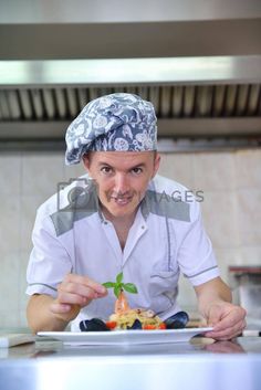 a man in a chef's hat preparing food on top of a plate at a restaurant