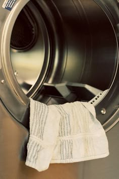 a white towel sitting on top of a dryer in front of a washer