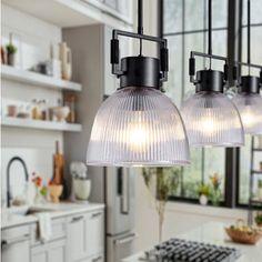 three lights are hanging from the ceiling in a kitchen