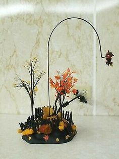 a vase filled with flowers and plants on top of a white countertop next to a marble