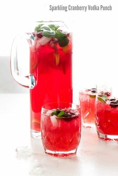 three glasses filled with red liquid and garnished with mint