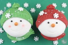 two frosted snowmen with hats and scarves on their heads, one is green and the other is red