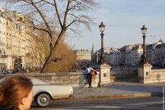 a woman standing next to a white car on a street