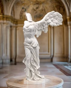 a white statue with angel wings in a room