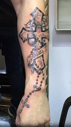 a person with a cross tattoo on their foot