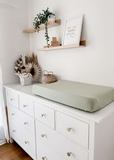 there is a white dresser with drawers on it