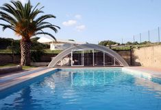 an empty swimming pool surrounded by palm trees