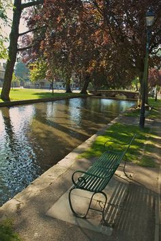 a park bench sitting on the side of a river