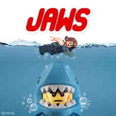 a toy shark with its mouth open in front of the words jaws on top of it