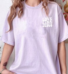 This unisex size T-shirt made at Naptime is an awesome way to show your faith! This short sleeve t shirt fits like a well-loved favorite, featuring an irresistibly soft cotton and scoop neck. Heavyweight, comfy unisex fit, most ladies tell us they run "loose fitting". Stonewashed super soft cotton material, with a straight hem perfect for tucking or tieing. Designed by Michelle @ Naptime and cut and heat pressed in-store with premium heat transfer vinyl that’s designed to last. Model is wearing color Violet 100% cottonFeatures: Side-seamed. Retail fit. Unisex sizing. Christian Jewelry Necklaces, T Shirt Fits, Chest Design, Love Like Jesus, Essential Oil Roller Bottle, Wearing Color, Color Violet, Shirt Fits, Short Sleeve T Shirt