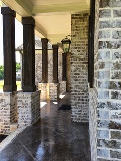 an empty walkway between two brick pillars