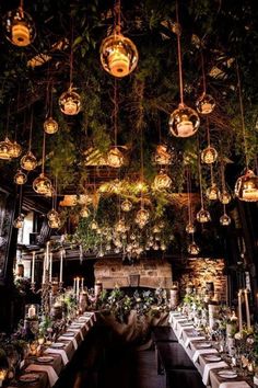 the dining room is decorated with hanging lights and greenery for an elegant touch to the space