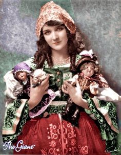 an old photo of a woman holding dolls