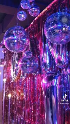 disco ball chandeliers hanging from the ceiling in a room with purple and red lights