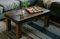 a coffee table with an ice cream tray on it in front of a gray couch