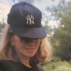 a woman wearing a new york yankees hat and sunglasses