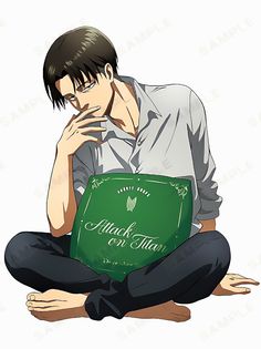 a man sitting on the ground holding a green book with his hands to his face