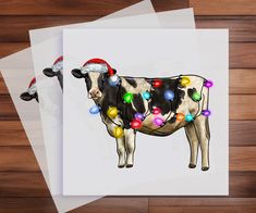 a cow with christmas lights on it's back standing in front of three sheets of paper