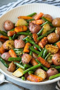 a white bowl filled with potatoes and green beans