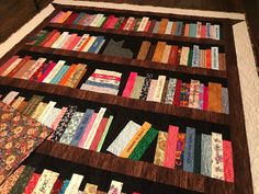 a quilted book shelf with many books on it