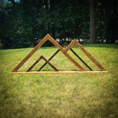 three wooden frames sitting on top of a lush green field