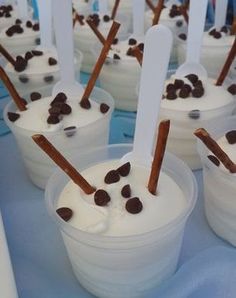 ice cream with chocolate chips in it and sticks sticking out of the cups to eat