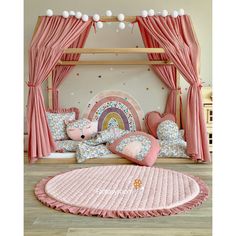 a bedroom with pink curtains and pillows on the bed, next to a round rug