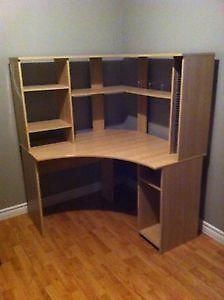 an empty corner desk with shelves on the wall and hard wood flooring in front of it