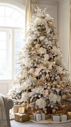 a white christmas tree with gold and silver decorations