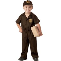 a young boy dressed in a brown uniform and holding a book, standing with his hands on his hips